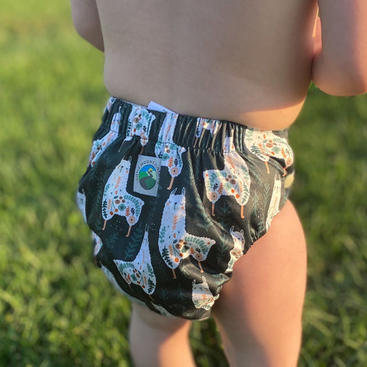A reusable cloth diaper with gray lining, llama and ferns folk art print on the outer PUL. Light Gray snaps.
